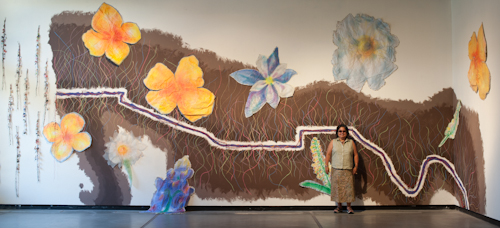 Consuelo Jimenez Underwood in front of 'undocumented borderflowers' at the Conley Art Gallery